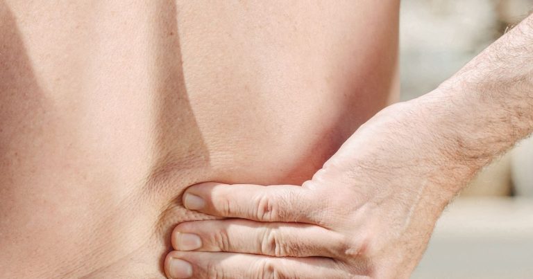 男子手扶后腰疼痛