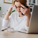 女士长时间伏案坐在笔记本电脑前，久坐是肌筋膜炎常见诱因